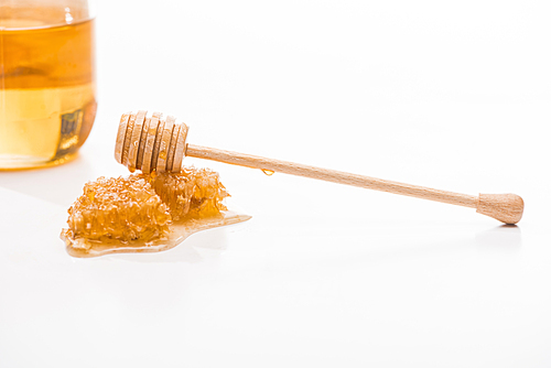 honeycomb with sweet honey and wooden honey dipper near jar isolated on white
