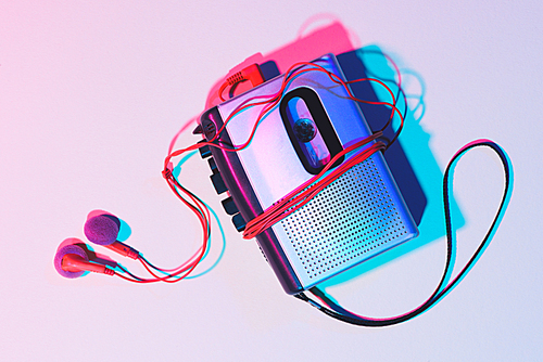 toned picture of retro cassette player and earphones on tabletop