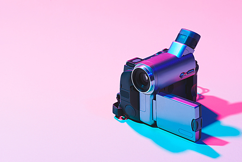 close up view of digital video camera on pink background