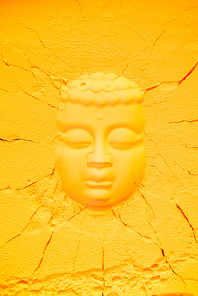top view of buddha head shape on orange flour texture with cracks
