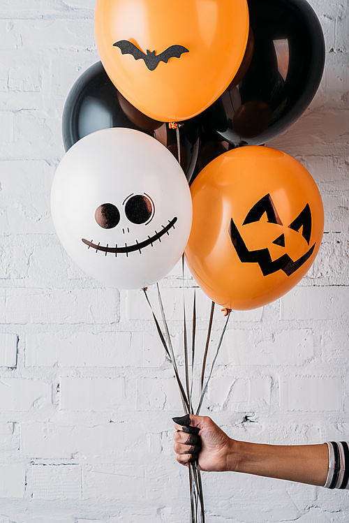 cropped shot of woman holding various halloween balloons