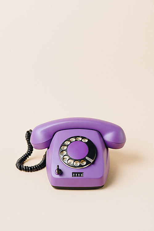 one purple vintage telephone on beige