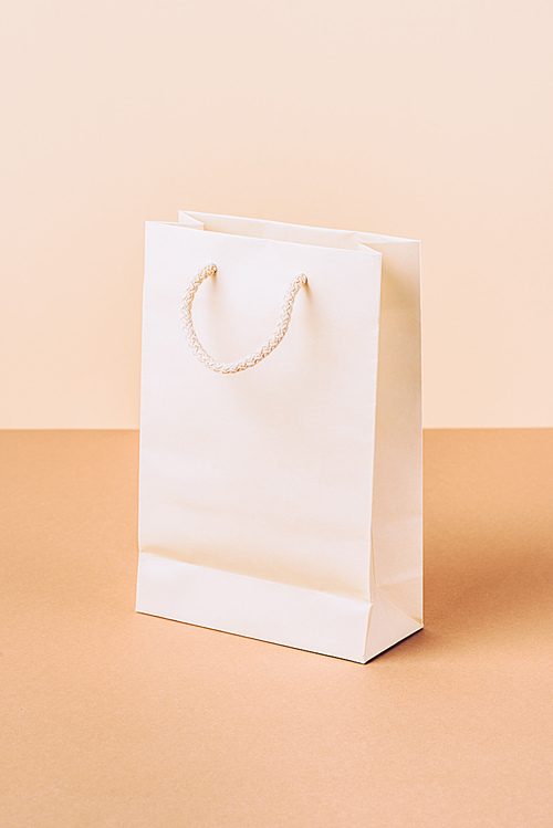 white paper shopping bag on beige