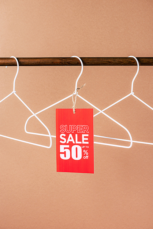 hangers with red super sale tag - 50 percents discount for black friday shopping on beige