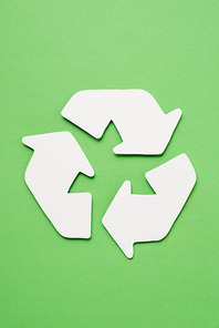 Top view of white trash recycle sign with arrows on green background