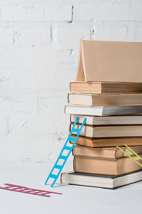 close-up view of pile of books and small colorful step ladders