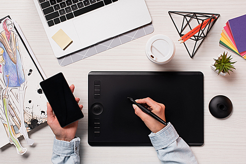 cropped view of designer using graphics tablet, pen and smartphone with blank screen, flat lay