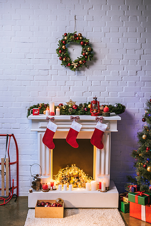 Fireplace with decorations near Christmas tree at home