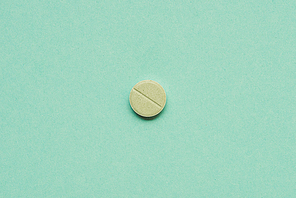 top view of round tablet on green background