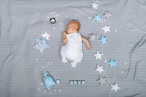 overhead view of adorable sleeping infant baby with decorations around