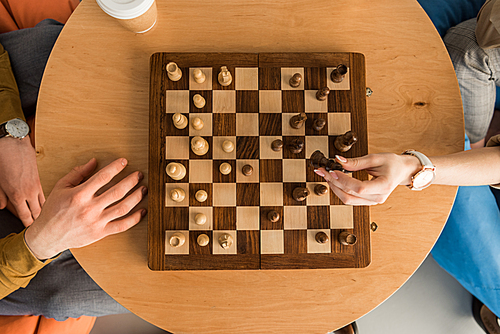 cropped shot of young man and woman playing chess