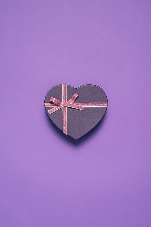 close up view of heart shaped gift box isolated on purple