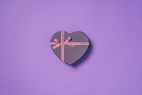 close up view of heart shaped gift box isolated on purple