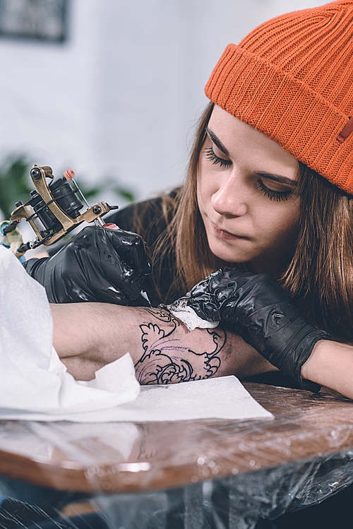 Boy and female tattoo master during tattoo process in studio