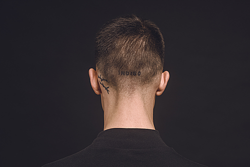 Rear view of tattoos on male neck isolated on black
