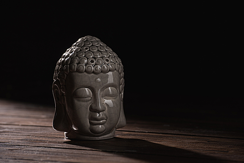 sculpture of buddha head on wooden table