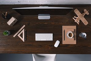 top view of desktop computer and office supplies on wooden table