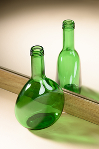 close up view of green glass bottle reflection in mirror