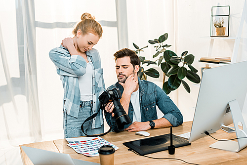 professional young photographers using photo camera while working together in office