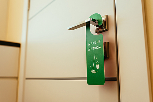 green sign with make up my room lettering on door handle, cleanup hotel service