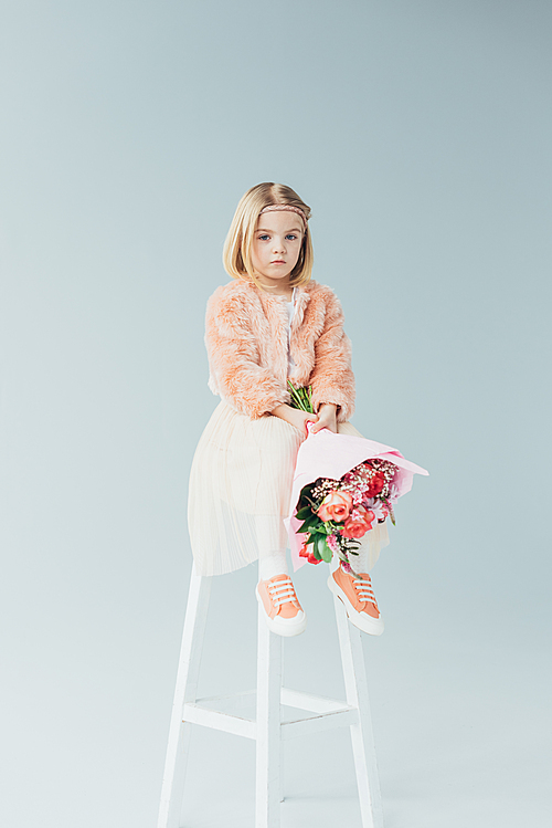 pensive-kid-in-faux-fur-coat-and-skirt-sitting-on-highchair-and