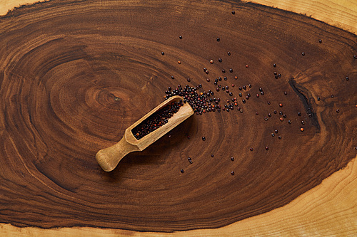 top view of black quinoa seeds in wooden spatula