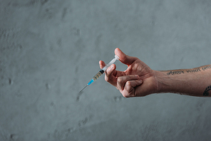 cropped shot of junkie holding heroin syringe