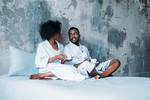 African american couple sitting in bed with cups of coffee | 유토이미지 | 상세 ...