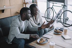 african american businesspeople discussing work during business meeting in cafe