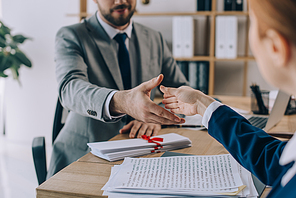 partial view of lawyers shaking hands on meeting in office