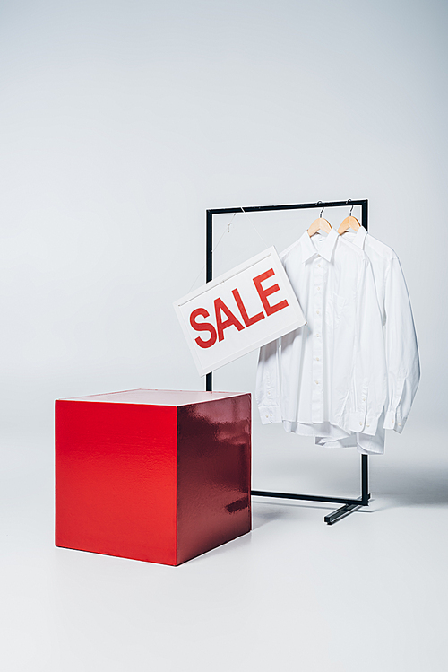 red cube, shirts on hangers and sale sign, summer sale concept