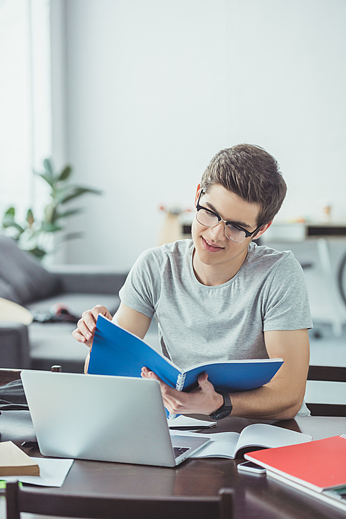 유토이미지 | male student doing homework with copybooks and laptop at home