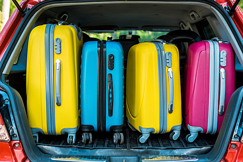 colored travel bags in car trunk