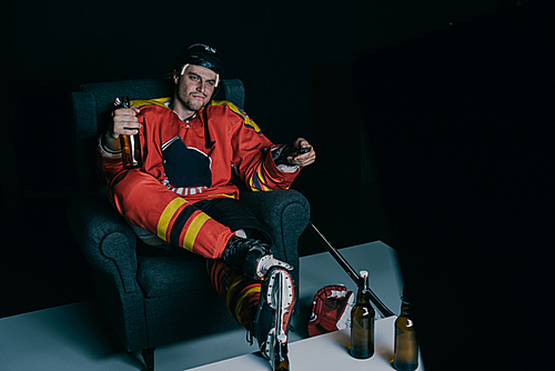 hockey player drinking beer and watching tv on black