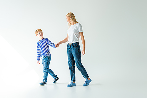 mother and son holding hands and looking at each other on white