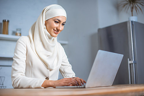 smiling young muslim woman using laptop at home | 유토이미지 | 상세페이지 | 베이직샵 ...