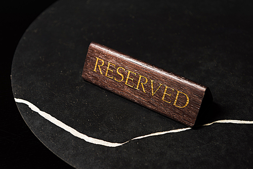 reserved sign on black table in cafe with copy space