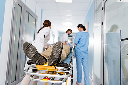 Doctors in uniform transporting patient to operating room