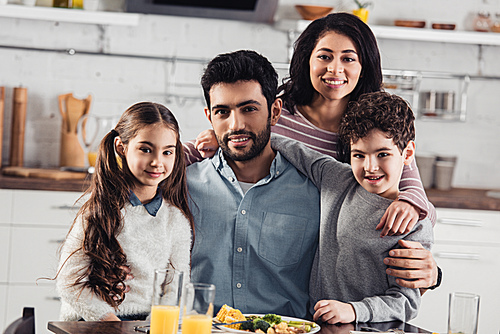 cheerful hispanic family smiling while  at home
