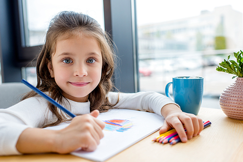 adorable kid holding colored pencil and