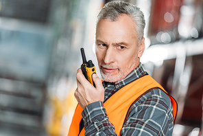 senior worker using walkie talkie in shipping stock