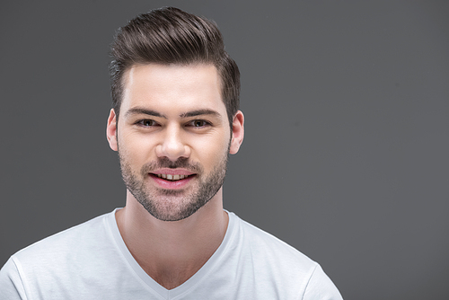 portrait of handsome smiling bearded man, isolated on grey