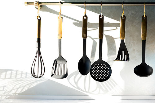 close-up view of various utensils hanging in kitchen
