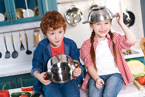 adorable children having fun with utensils in kitchen