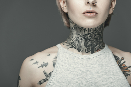 cropped view of attractive tattooed girl, isolated on grey