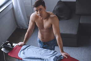 high angle view of sexy shirtless man standing near ironing board