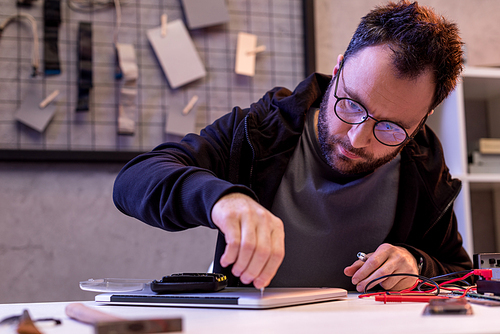 man figing digital tablet with screwdriver in hand