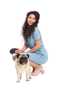attractive young woman with leashed pug isolated on white