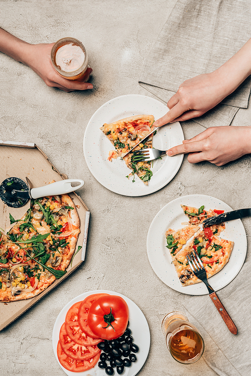 유토이미지 | Close-up view of friends sharing pizza and drink on light background