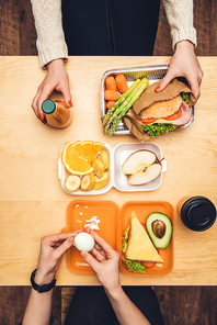 cropped image of women sitting at table and having luch